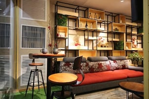 A modern living room with a sofa, two tables, and a bookshelf.