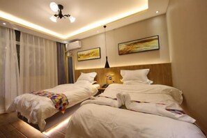 A hotel room with two beds, a ceiling light, a wall-mounted air conditioner, and two paintings. - Xinzheng Venice Fashion Hotel (Xinhua Road Zhonghua Road) (Xinzheng)