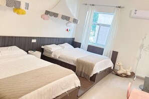 A hotel room with two beds, a window with curtains, a wall-mounted air conditioner, and a small wooden rocking horse.