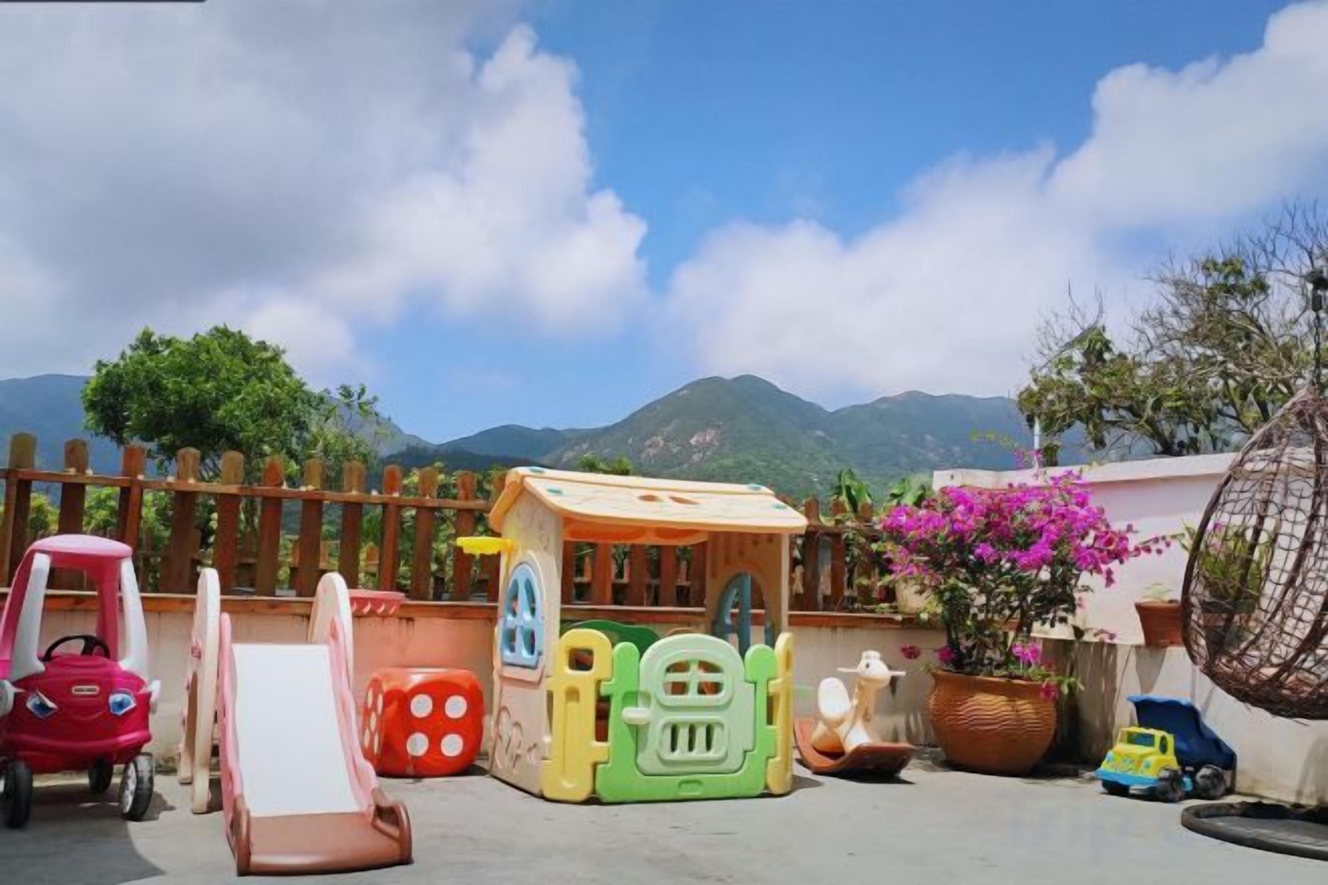 A children's play area with a slide, a small house, and a toy car.