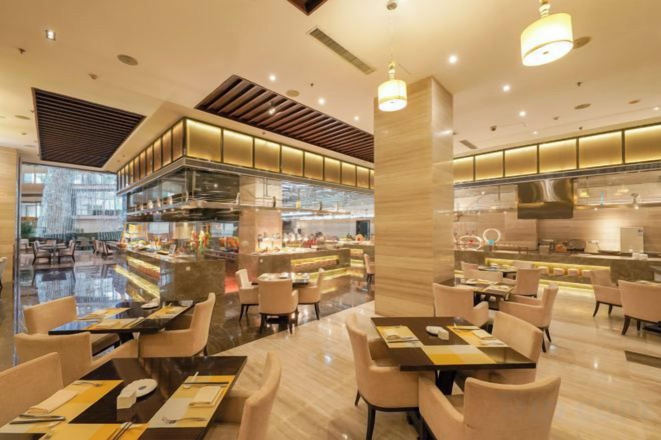 Un restaurante moderno con barra central, varias mesas y un diseño espacioso.