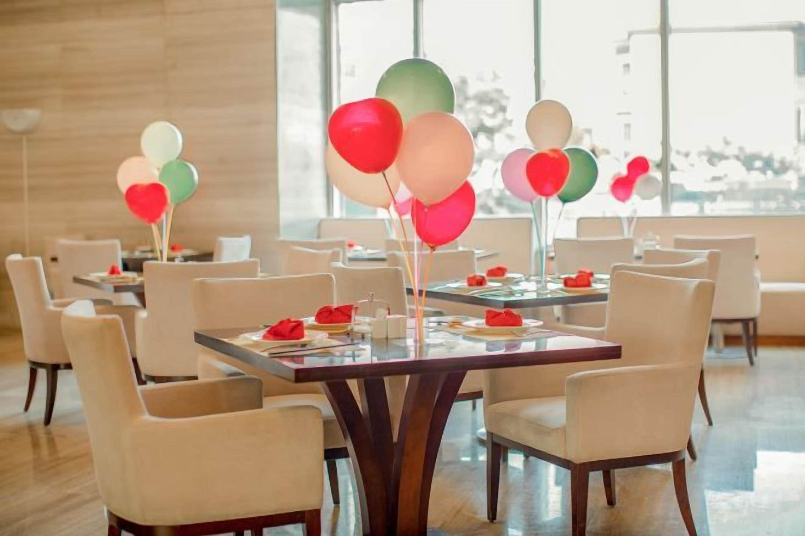 Ein Essbereich mit gedeckten Tischen, Stühlen und Ballons.