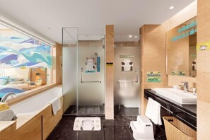 Un bagno moderno con cabina doccia in vetro, uno specchio grande e un pavimento in marmo nero.