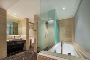 Un bagno moderno con doccia vetrata, una vasca da bagno indipendente e un mobile lavabo con uno specchio grande.
