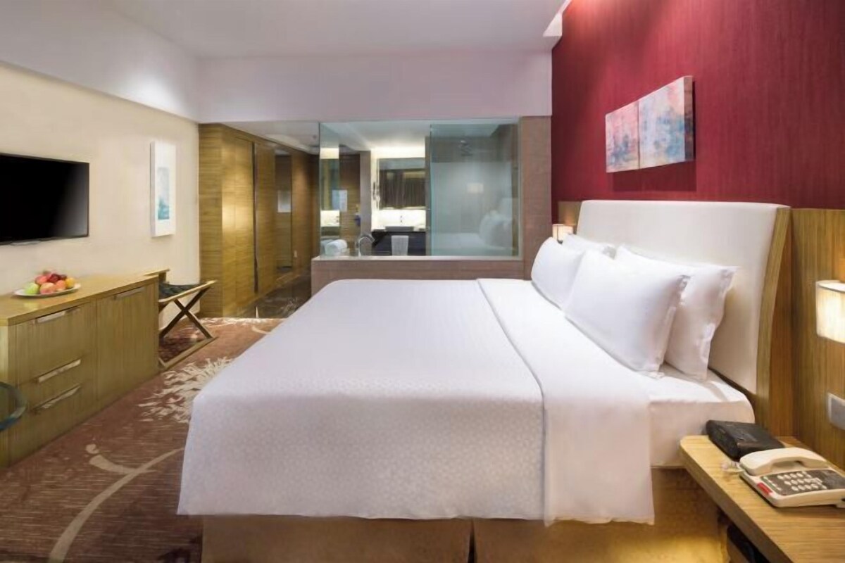 Camera d'albergo con un letto, una scrivania, un telefono e una televisione.