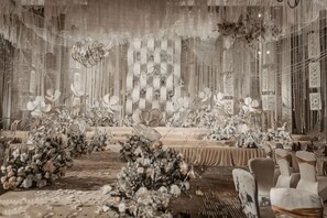Un espace événementiel élégant, avec une longue table, des compositions florales et des chaises raffinées.