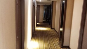 A hotel corridor with a striped carpet and a wooden floor. - Blue City Exepress Hotel (Chengdu)
