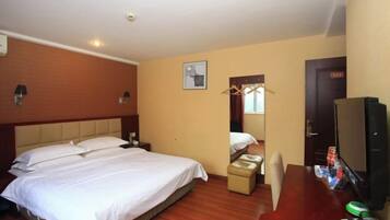 A hotel room with a bed, a desk, a television, and a mirror.