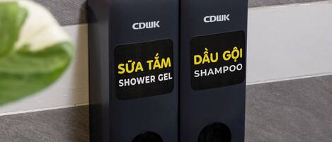 Two push-button dispensers for shower gel and shampoo.