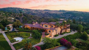 A large, two-story house with a landscaped garden, a swimming pool, and a view of the surrounding hills. - Keys Creek Main House by Avantstay Luxury 9bdr Estate (Valley Center)