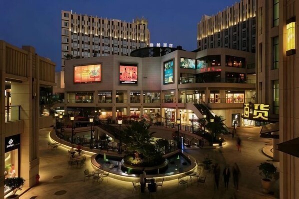 A multi-level shopping mall with a central atrium, escalators, and a fountain. - Bo Man Hotel (Pu'er)