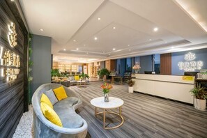A modern hotel lobby with a reception desk, seating area, and a reception counter. - Bo Man Hotel (Pu'er)
