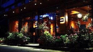 A building with a wooden facade, large windows, and a well-lit entrance. - YunZong hotel (Chongqing)