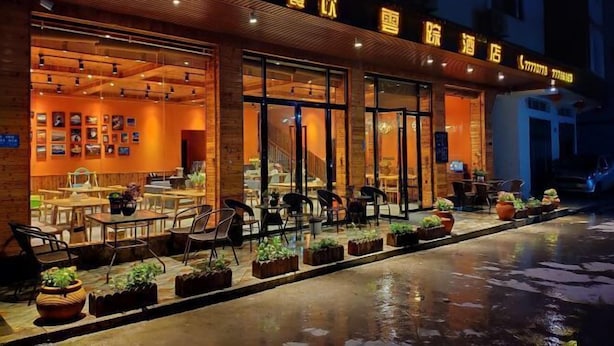 A restaurant with outdoor seating, a brick facade, and a sign with Chinese characters. - YunZong hotel (Chongqing)