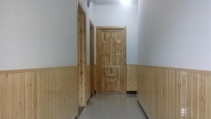 A hallway with wooden paneling on the walls and a wooden door at the end. - Yunxiu Inn (Zhangjiajie)