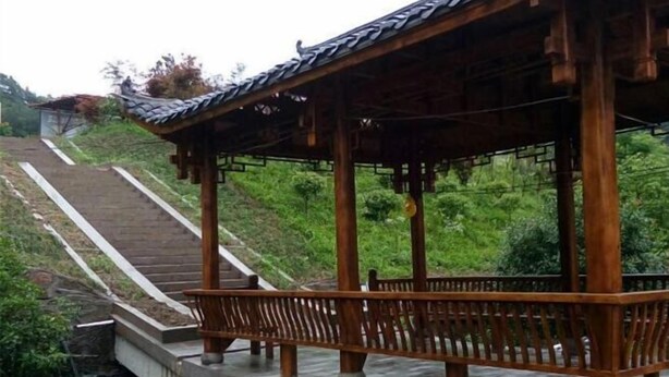 A traditional wooden pavilion with a tiled roof, situated on a stone platform with a metal railing. - Yunxiu Inn (Zhangjiajie)