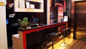 A bar area with a counter, stools, and a mirror. - Guests City Daren Theme Hotel (Laibin)
