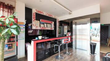 A modern bar area with a counter, stools, and a large mirror.