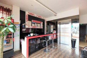 A modern bar area with a counter, stools, and a large mirror.