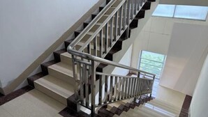 A modern staircase with metal railings and a view of the outdoors through a window. - Guests City Daren Theme Hotel (Laibin)
