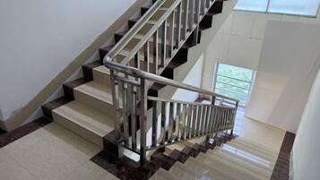A staircase with a metal handrail and a view of a window at the top.