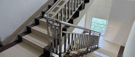 Una escalera con barandilla de metal y vista a una ventana en la parte superior.