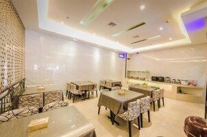 Un comedor moderno con mesas y sillas, una zona de cocina y una barra.