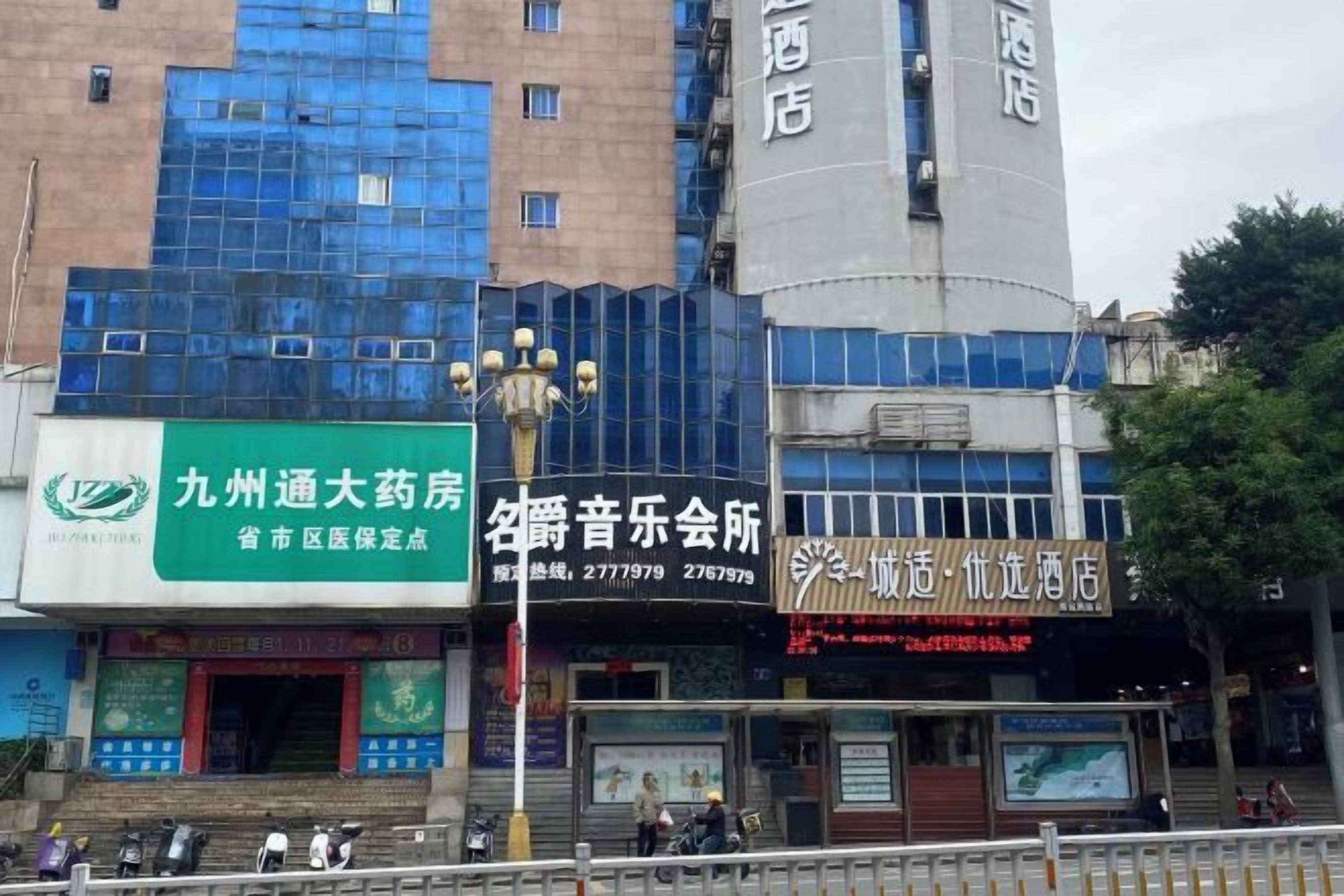 A building with multiple commercial establishments, including a pharmacy and a music hall.