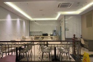 A modern dining area with a glass partition, metal railing, and contemporary furniture. - City Comfort Hotel (Ningde Jiaocheng District Government Branch) (Ningde)