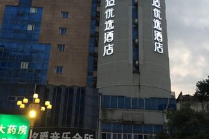 Un hotel con un letrero vertical llamativo que indica su nombre y una gran estructura cilíndrica.