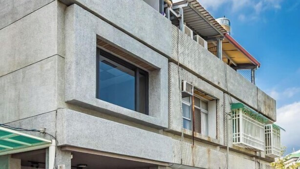 A multi-story building with a concrete facade, large windows, and a balcony with a metal railing. - Hualien Go (Hualien)