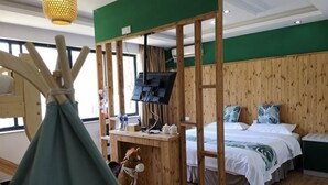 Una habitación con una cama, un escritorio con televisor, un separador de madera y una ventana.
