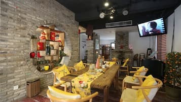 Un restaurante con pared de ladrillo, muebles de madera y una televisión.