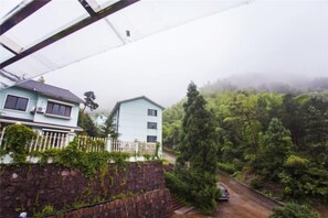 Un quartier résidentiel avec des maisons, un mur de pierre et une route.