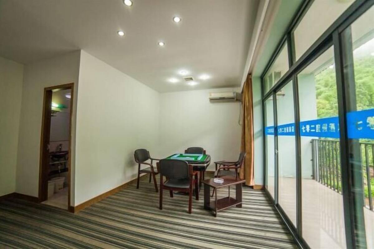 Une chambre d’hôtel avec un tapis à rayures, une table de billard et une petite table entourée de chaises.