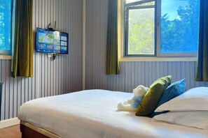 A bedroom with a bed, a television mounted on the wall, and a window with curtains. - Jiangbin Hotel (Shaoxing)