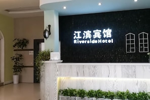 A hotel reception desk with a sign reading 'Riverside Hotel.'
