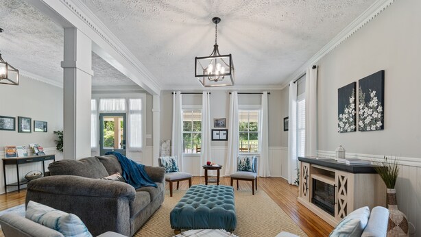 A spacious living room with a fireplace, comfortable seating, and a dining area with a table set for breakfast. - Charming Inn as you Enter Cherokee National Forest, The Munz Room 6C (Tellico Plains)