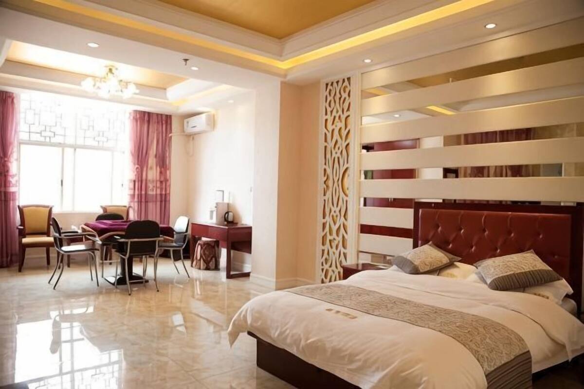 A bedroom with a large bed, a desk, and a chair.