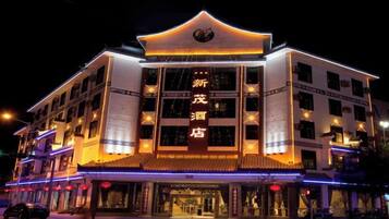 A multi-story hotel with illuminated signage and traditional architectural design.