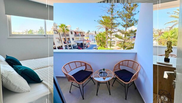 Un hotel moderno con balcón, cama y vistas de la ciudad.