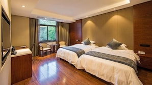 A hotel room with two beds, a desk, a chair, and a window with curtains. - Wuyishan Guanjing Shanfang Hotel (Wuyishan)