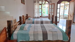 Un lit double avec une couette, une tête de lit en bois et une fenêtre avec des rideaux.