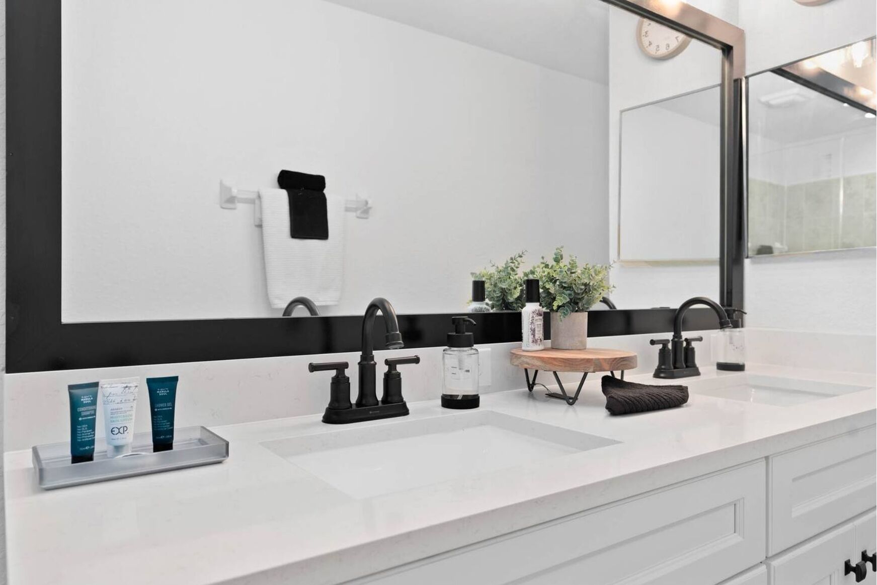Een moderne badkamer met twee wasbakken, een grote spiegel en een houten wastafelmeubel.