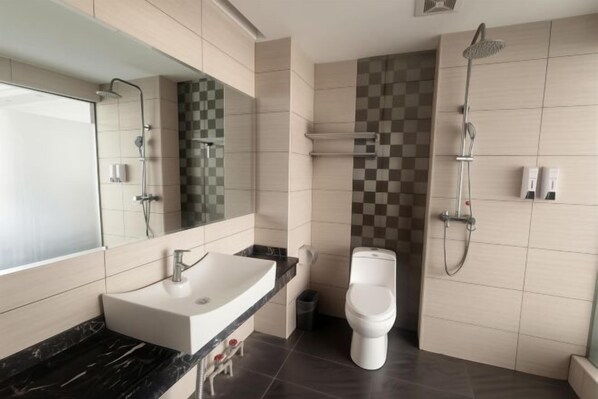 Un baño moderno con un espejo grande, un lavabo, un inodoro y una ducha.