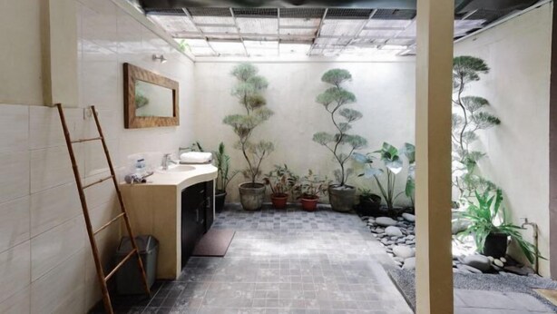 A bathroom with a sink, mirror, and potted plants. - The Lavana Villa Abimanyu 3 Seminyak (Bali)