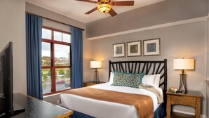 A hotel room with a bed, two bedside lamps, a ceiling fan, a TV, and a window with curtains. - 1Bed Deluxe at Great Smokies Lodge! (Sevierville)