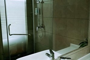 Ein modernes Badezimmer mit Duschkabine aus Glas, einem weißen Waschbecken und einem Spiegel.