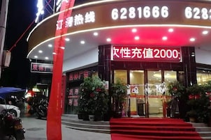 Un edificio con una entrada roja destacada y señalización iluminada.