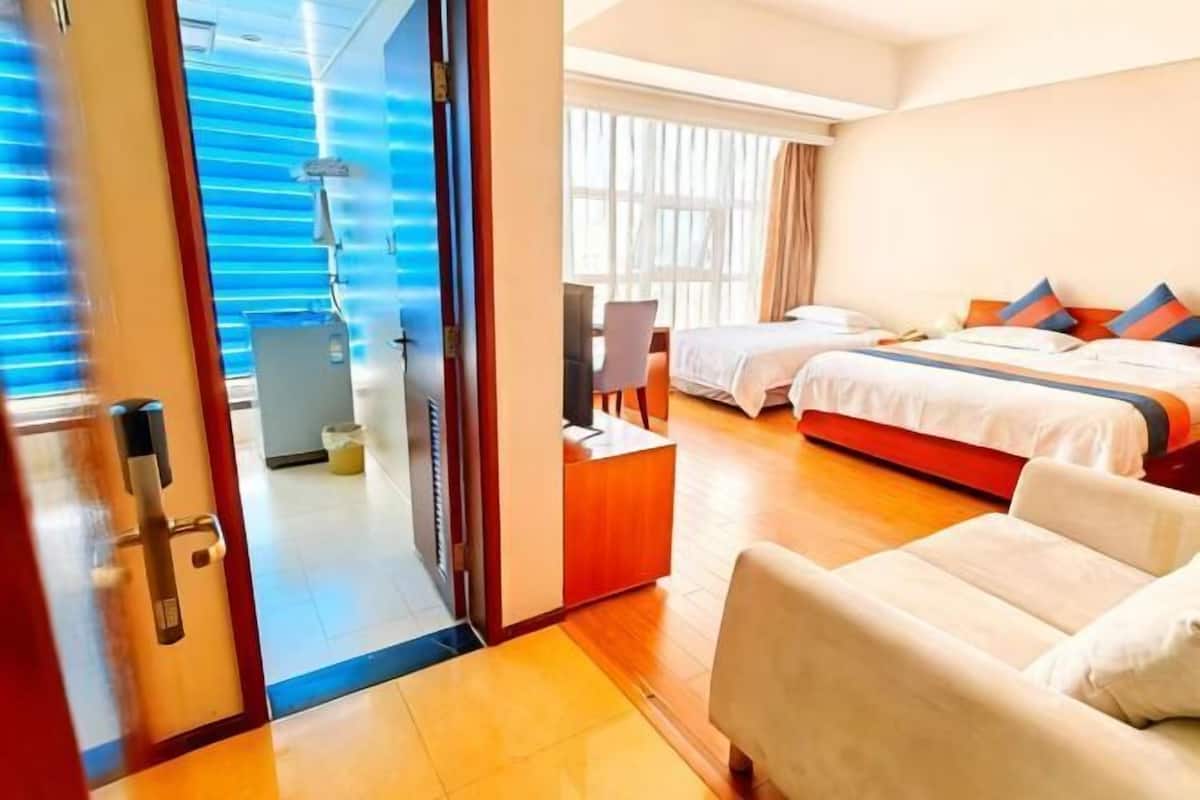 Habitación de hotel con cama, escritorio, silla y vistas al exterior.